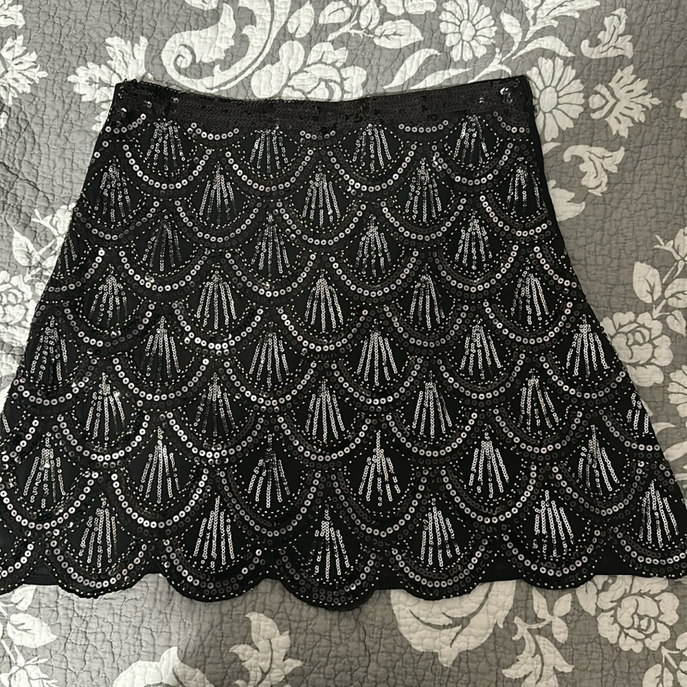 Black sequin skirt with scalloped bottom.